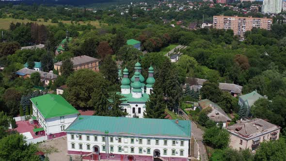 Nice top view of the church. Green domes among the trees. Monastery in the forest. alt