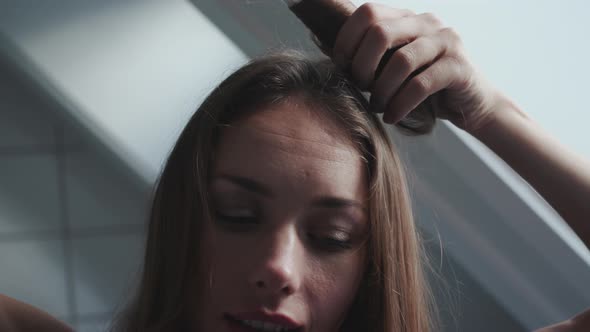 Green Eyed Woman Using Curling Tongs