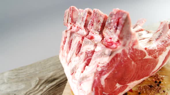 Raw beef ribs and ingredients on wooden board