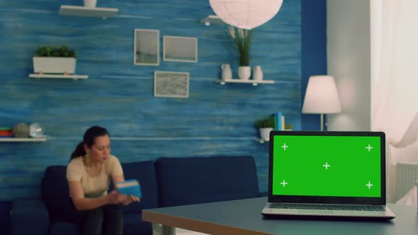 Caucasian Female Working on Laptop Computer with Mock Up Green Screen Chroma Key Display