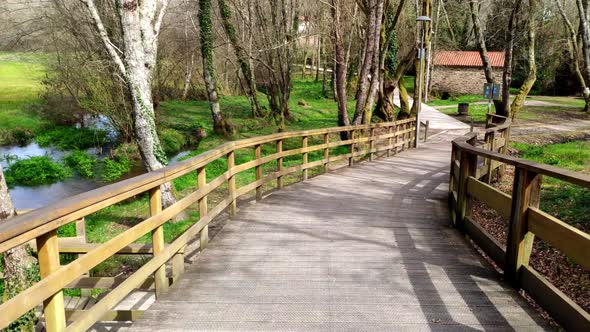 POV Walking Along Empty Elevated Wooden Promenade In Local Park At Ordes, Coruna