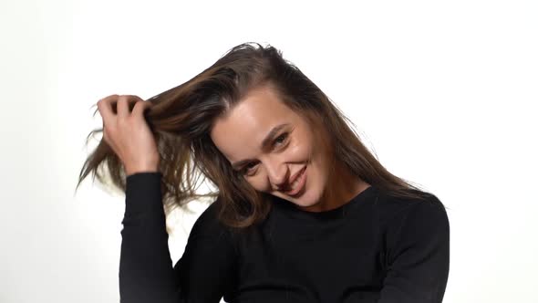 Gorgeous Girl in a Black Jumper is Throwing Back Her Hair and Smiling