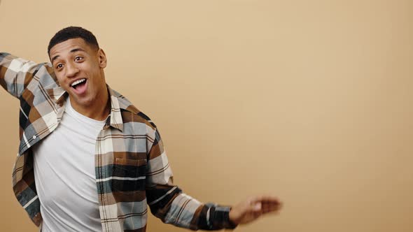 Young Flexible Happy African American Guy Moving Aside Dancing Wavy Gestures with Hands Smiling to