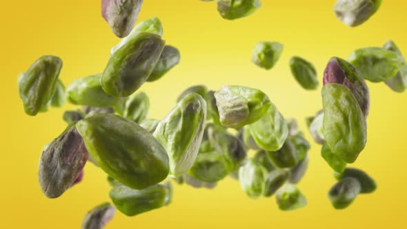 Flying of Peeled Pistachios in Yellow Background