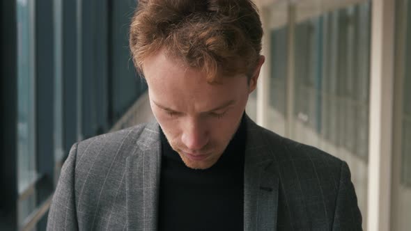 Portrait of handsome man in suit with hairstyle looking to camera. Close up of male person in stylis