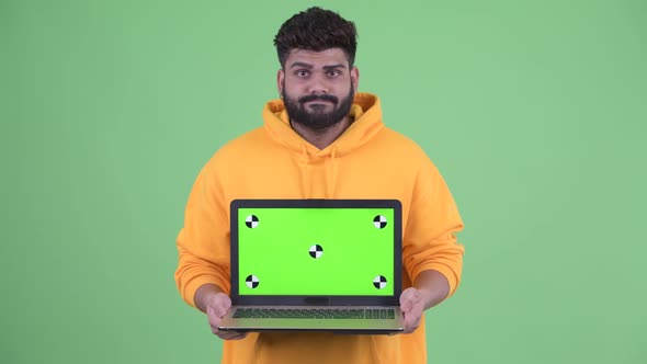 Stressed Young Overweight Bearded Indian Man Showing Laptop