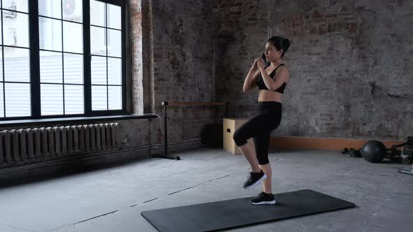 Young Indian Athletic Woman Doing Sports Doing Exercise Jumping Bike Lifting her Legs Up