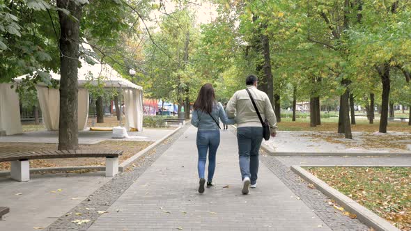 Autumn Cloudy Day City Park Man Woman Holding Hands Go Along Path View From Back