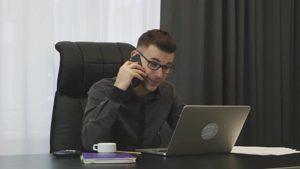 Man in suit and glasses talking on phone in modern office. Business corporate success concept