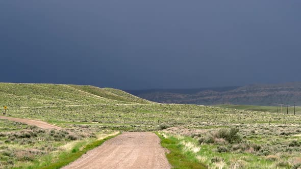 Lightning strikes in dark stormy clouds at the end of a dirt road