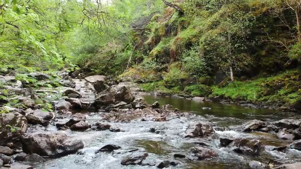 Cinematic drone shot of scottish highland waterfall