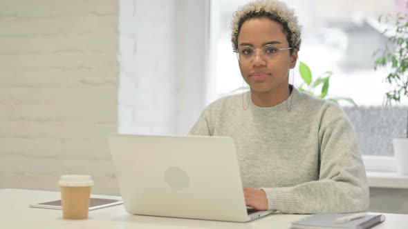 African Woman Shaking Head As No Sign While Using Laptop in Office