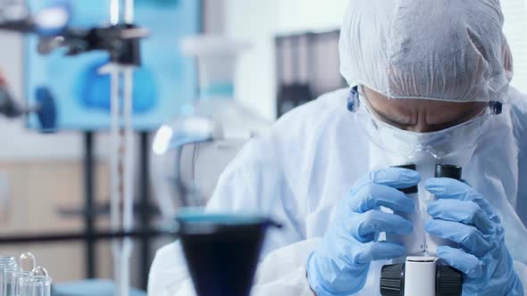 Dolly Shot of Scientist Looking Into a Microscope in Modern High End Laboratory