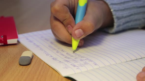 Closeup Hands of a High School Student Writing in English with a Fountain Pen