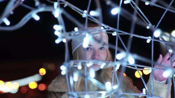 Girl Posing Against the Backdrop of Urban Christmas Illumination