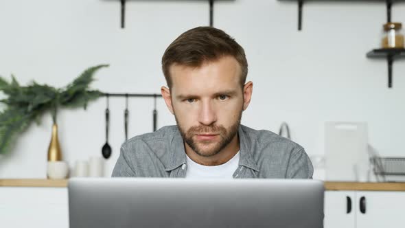 Close-Up Of A Young Thoughtful Freelance Man Looking at A Monitor Screen, Working