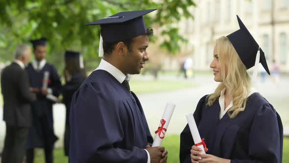 People in Academic Dress and Hats With Diplomas in Hands Talking, Graduation Day