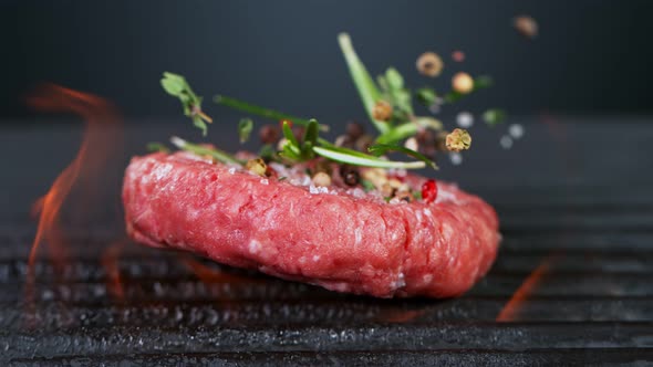 Super Slow Motion Shot of Falling Fresh Beef Hamburger Meat with Herbs on Grill at 1000 Fps