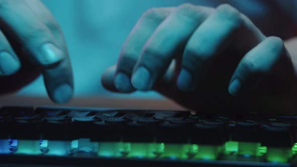 Gamer Typing on Backlight Keyboard Closeup Man Playing Video Game