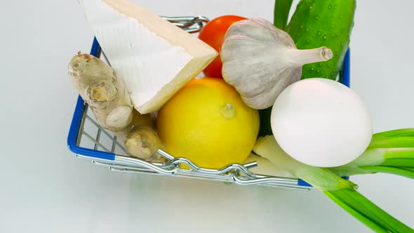 Top View. A Set Of Vegetables And Products From A Supermarket In A Grocery Cart Rotating