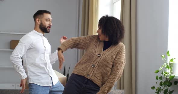 Closeup Caucasian Man and African American Curlyhaired Woman Couple Dancing in New House Rented