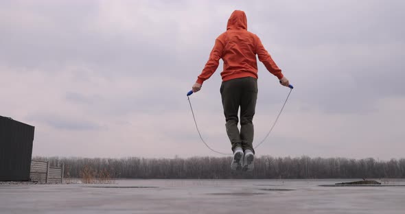 Young Man Skipping Rope Jumping Outdoor Back View