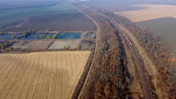 Panoramic Moving Freight Train Along Railway Tracks Trees Agricultural Fields