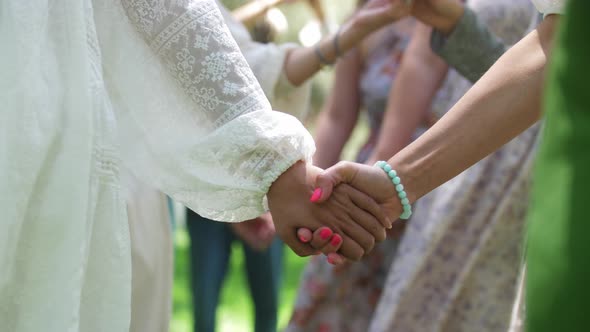 Women in Traditional Dresses Standing in a Circle and Holding Hands