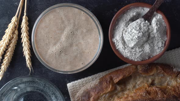 Yeast-free sourdough bread, flour, water and glass jar with dough leaven