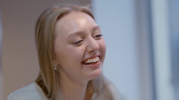 Headshot of Cheerful Young Caucasian Woman Laughing Out Loud Indoors