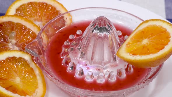 Red orange slices in rotating citrus juicer