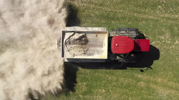 farm tractor spreading white powder amazing above view