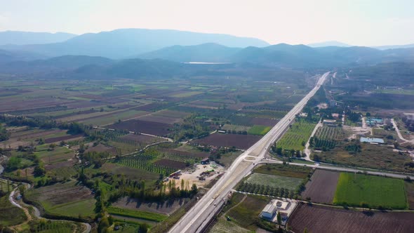 Aerial View of Country Road Along Agricultural Fields on a Summer Day