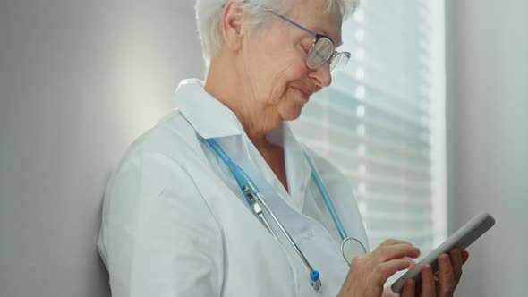 Happy mature female doctor in white robe