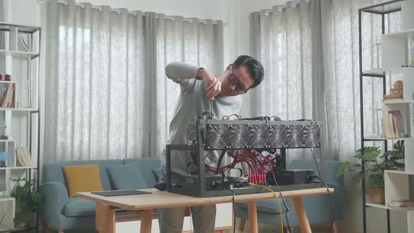 Asian Man Wearing Glasses Fixing The Mining Rig For Mining Cryptocurrency