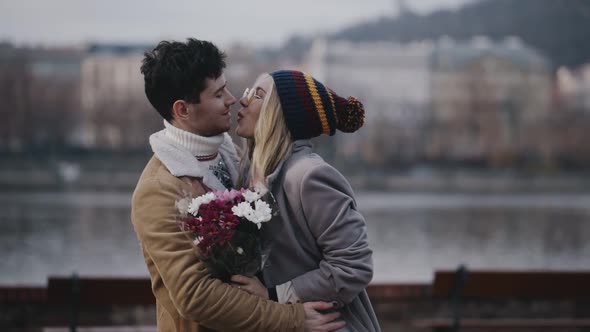 Romantic Moment of Blonde Girl and Brunette Guy Kissing and Huging on Waterfront