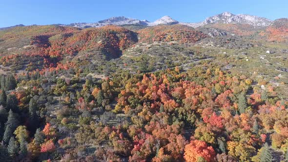 A drone flies over the rocks and slopes of  Dry Creek Trailhead in Alpine, Utah as leaves change int