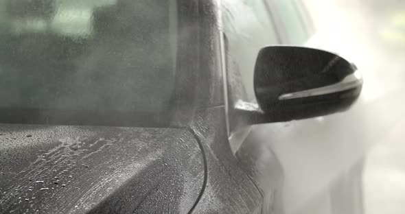 Washing a Black Car with High Pressure Cleaner