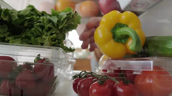 View Inside the Refrigerator Hand Takes Food From the Refrigerator