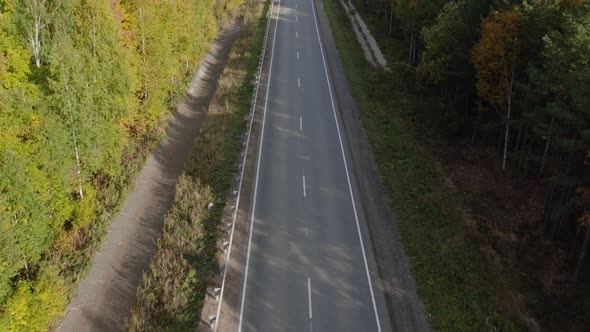 Asphalt road with traffic cars between forest in Ural