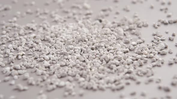 Clumping bentonite cat litter. Grey fine-grained toilet particles falling in slow motion