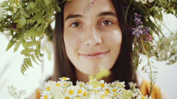 Portrait of Beautiful Woman in Flower Wreath with Chamomile Bouquet