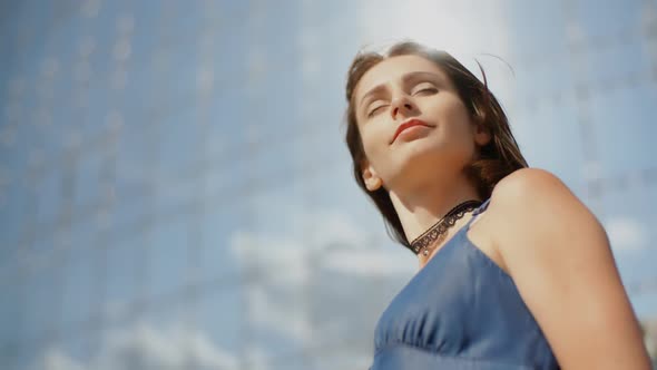 Portrait Of The Young Woman Model Posing In Front Of Blue Background