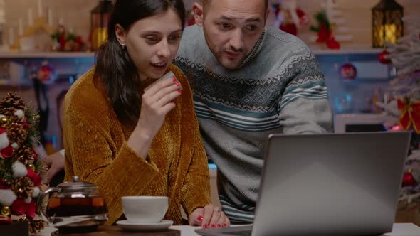 Festive Couple Doing Christmas Shopping Online with Credit Card