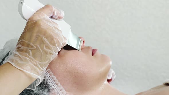 Ultrasonic scrabbing. Young woman receiving ultrasound cavitation facial peeling cleansing