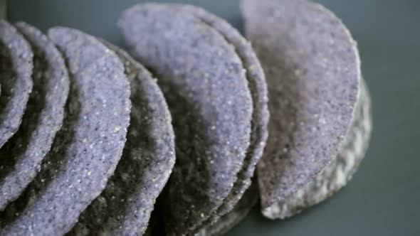 Blue corn taco shells on a gray background.