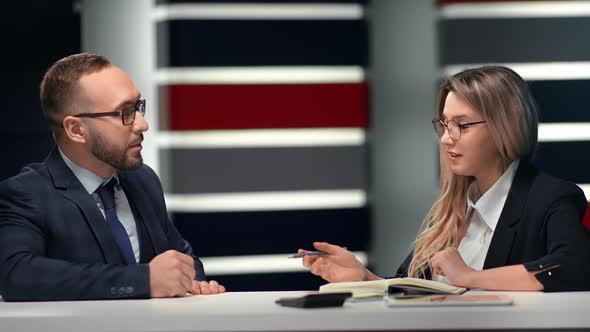 Two Business People Communicating Discuss Project Making Notes at Table