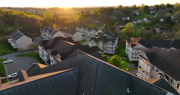 Colorful sunset over residential apartment building units in USA. American living. Aerial establishi