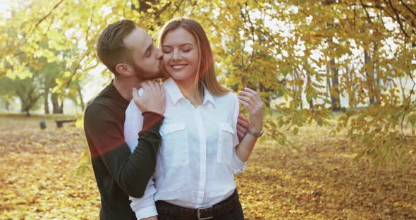 Lovely Man Comes Embraces Girl and Kisses Her They Caress Each Other in Park