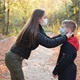 Woman Putting a Face Mask on Her Child Outdoors - VideoHive Item for Sale